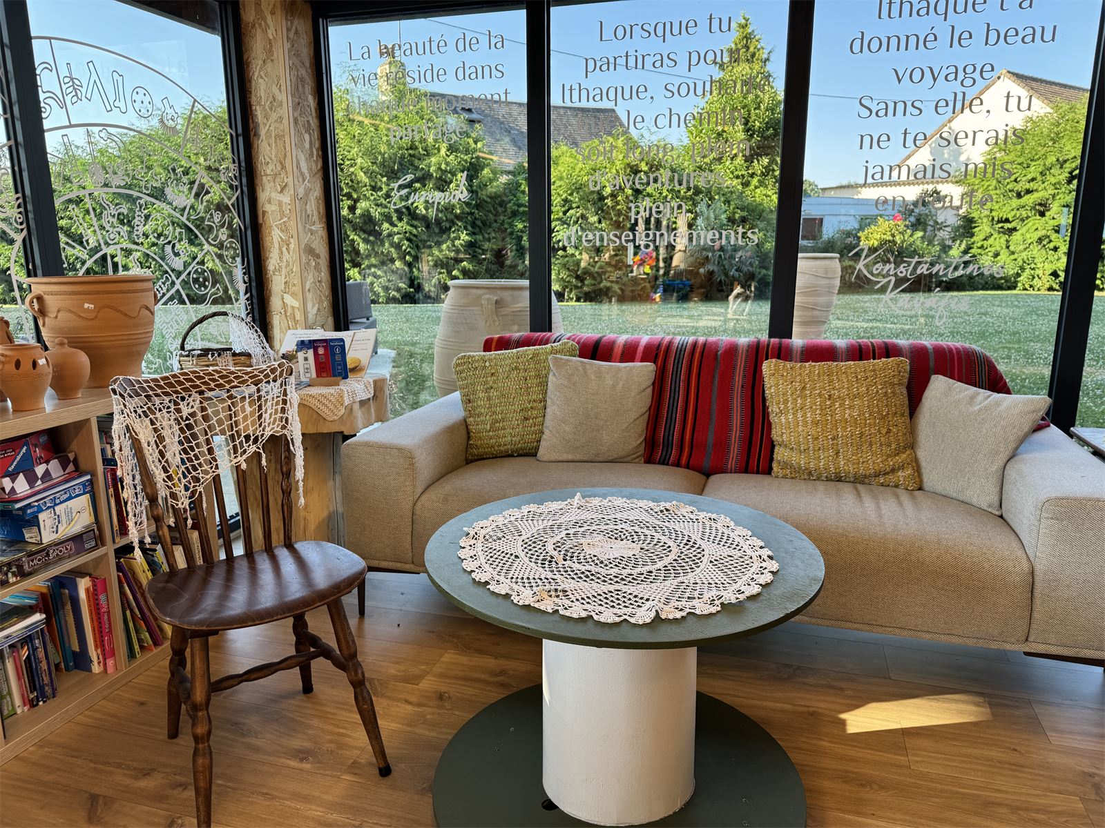 Coin salon de la boutique de Messei, avec le po&egrave;me d'Ithaque calligraphi&eacute; sur les baies vitr&eacute;es